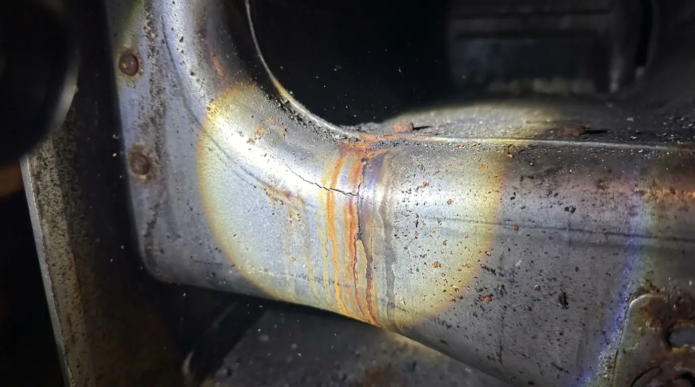 Crack in a furnace heat exchanger under a flashlight